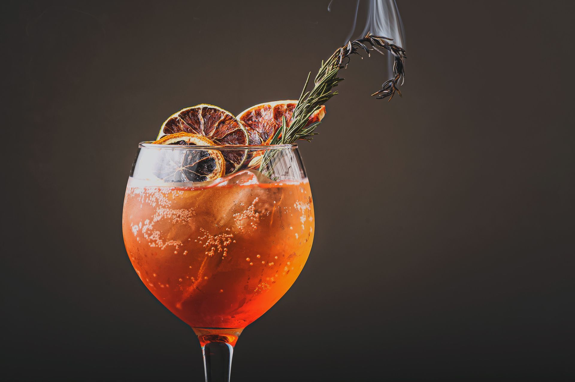 A close up of a drink in a wine glass with a splash coming out of it.
