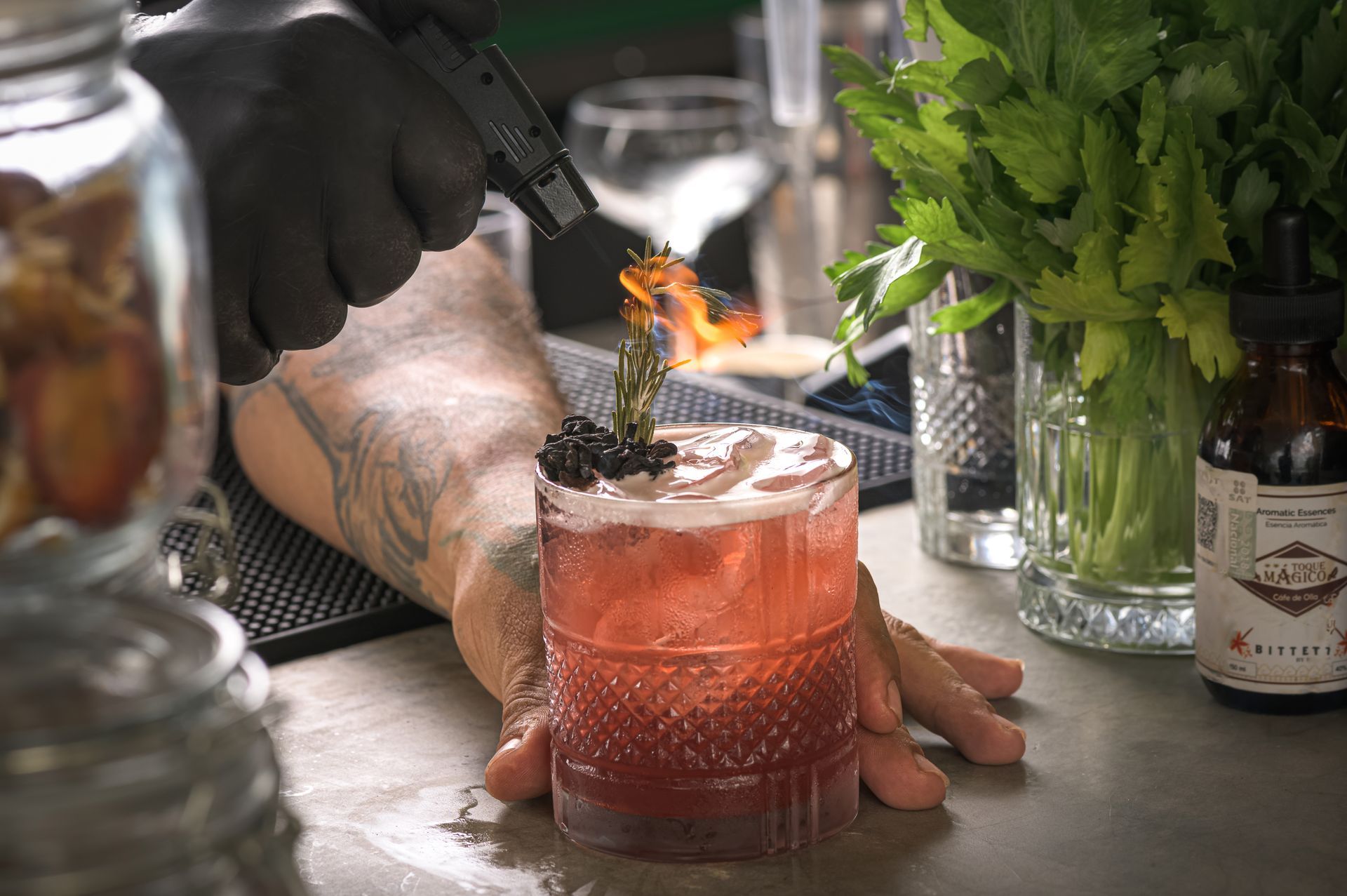 A bartender is lighting a drink with a lighter.