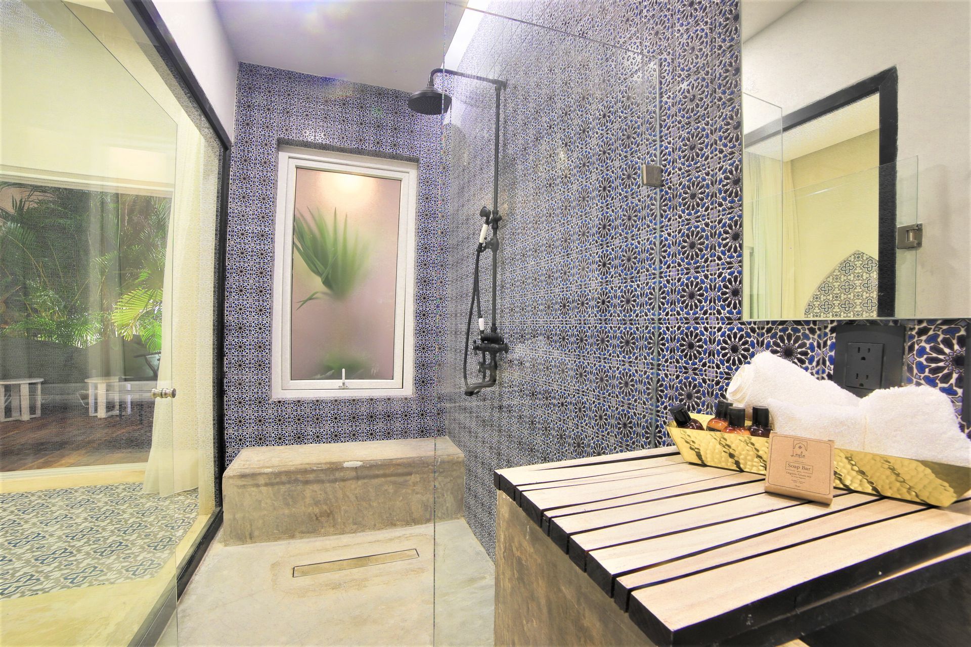 A bathroom with a walk in shower and a sink.
