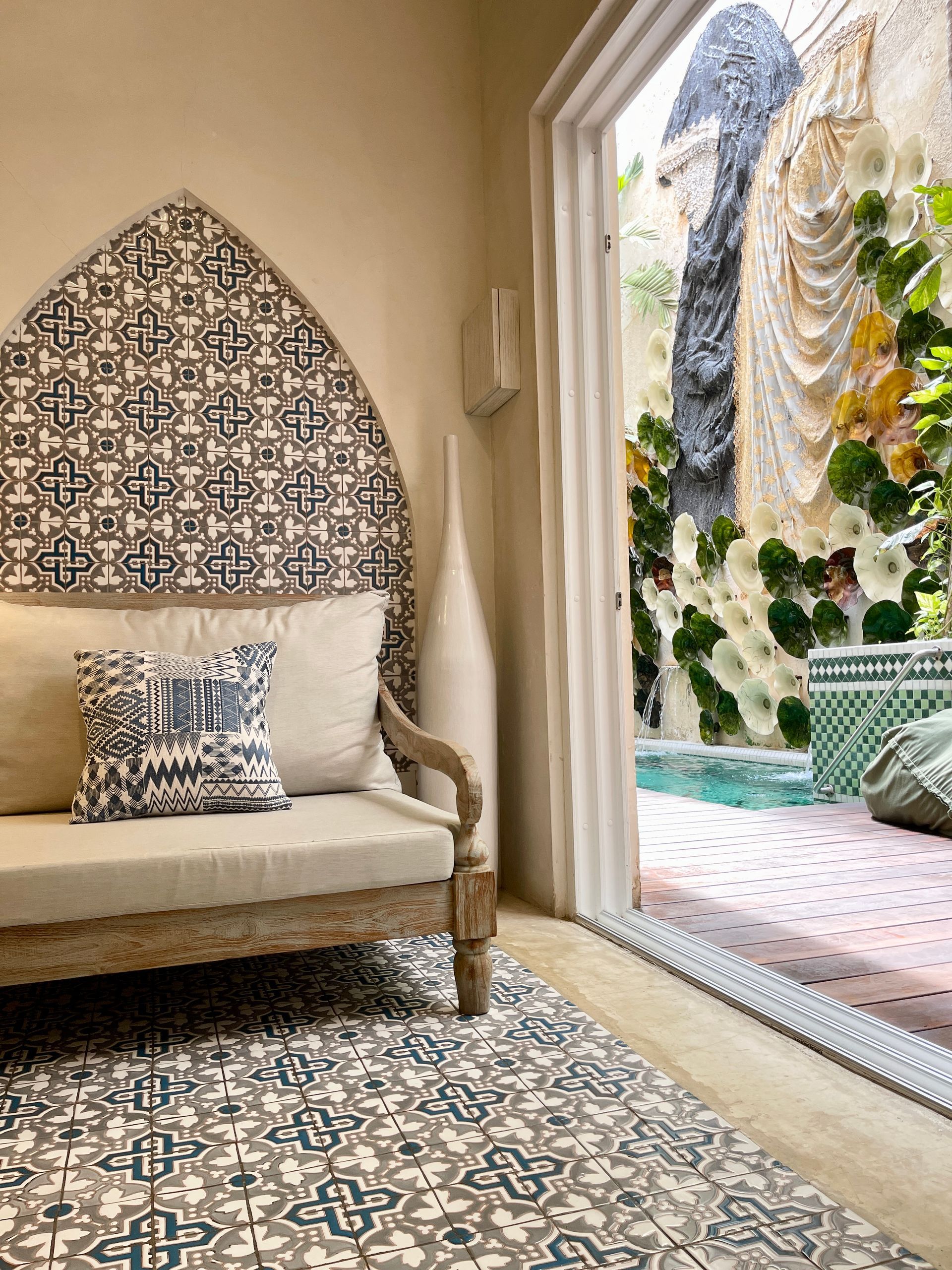 A living room with a couch and a rug and a view of a pool.
