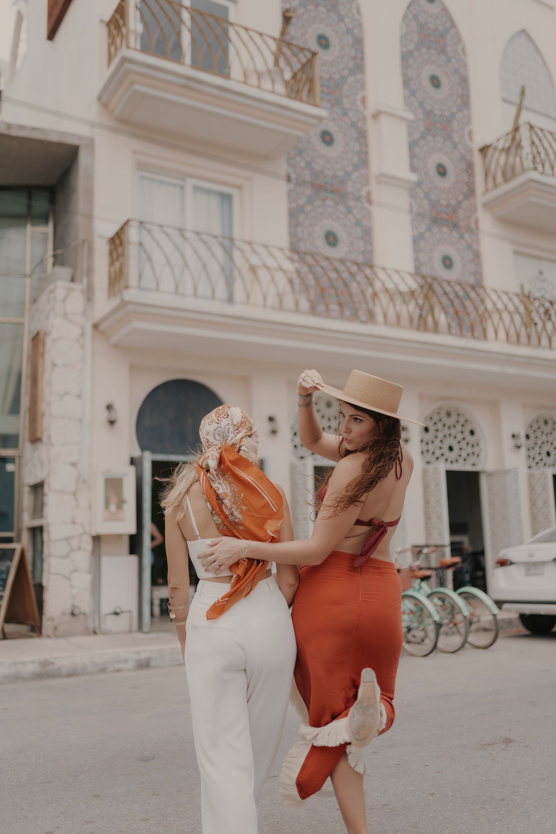 Two women are standing next to each other in front of a building.