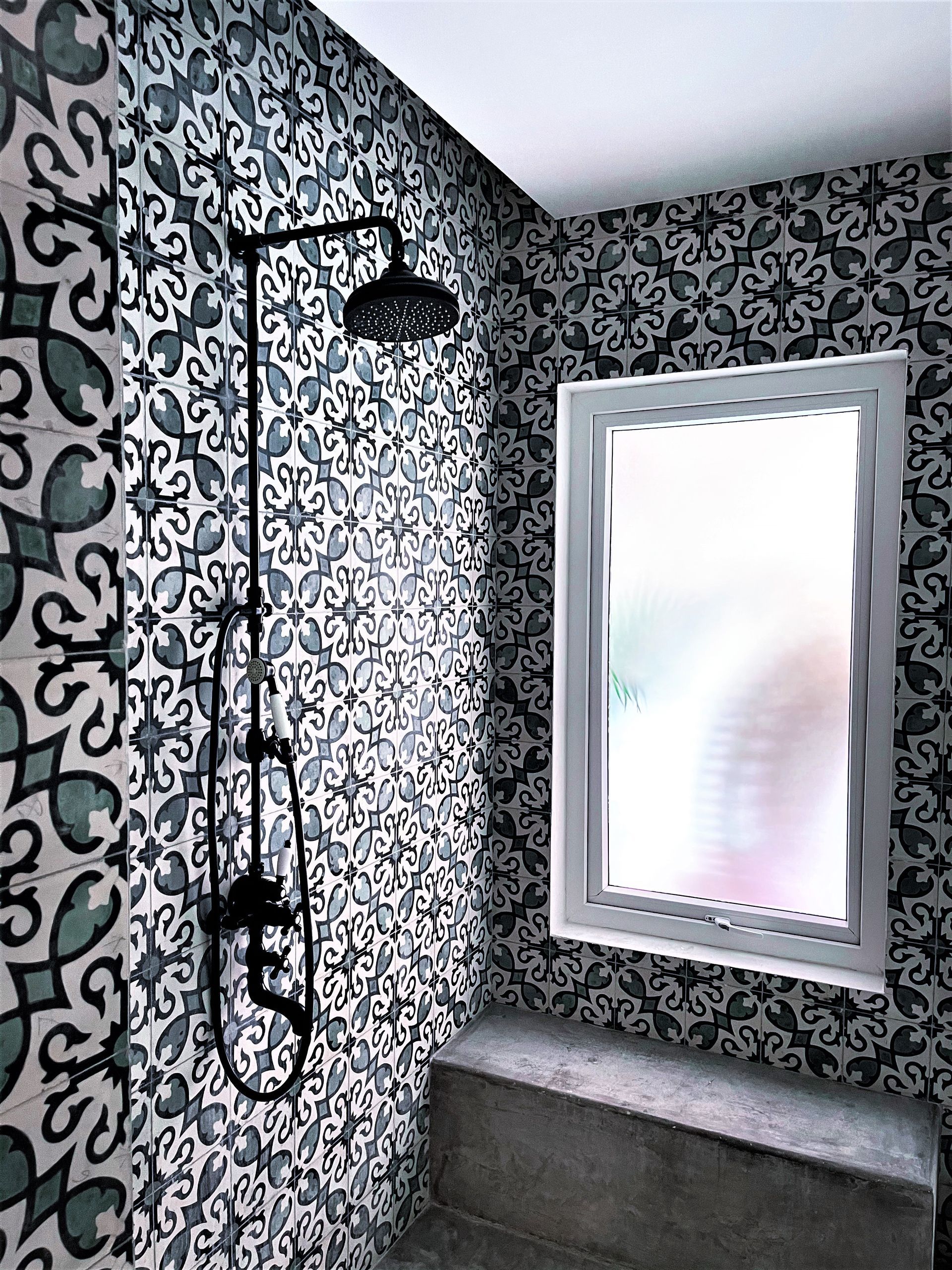 A bathroom with a shower and a window.