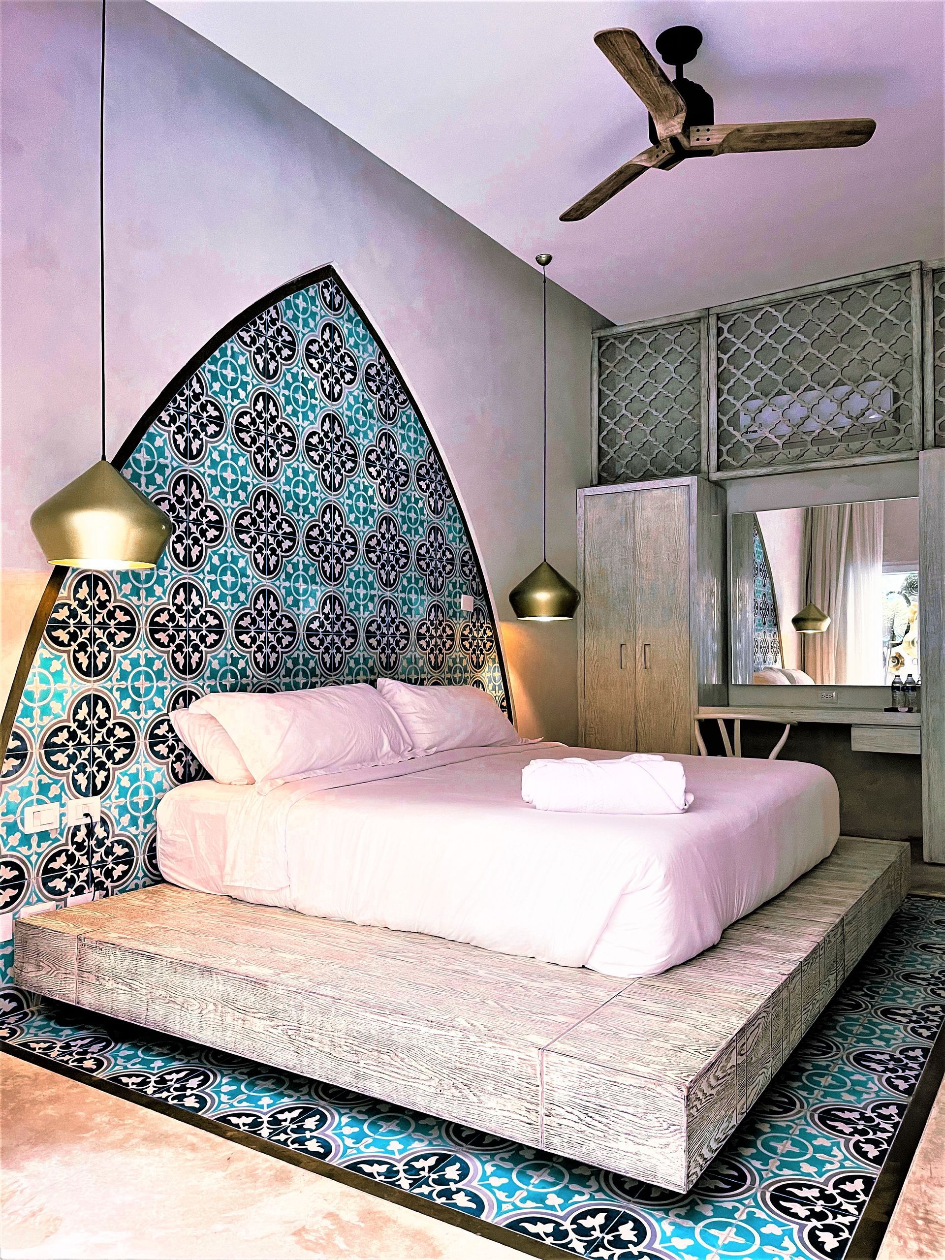 A bedroom with a large bed and a ceiling fan.