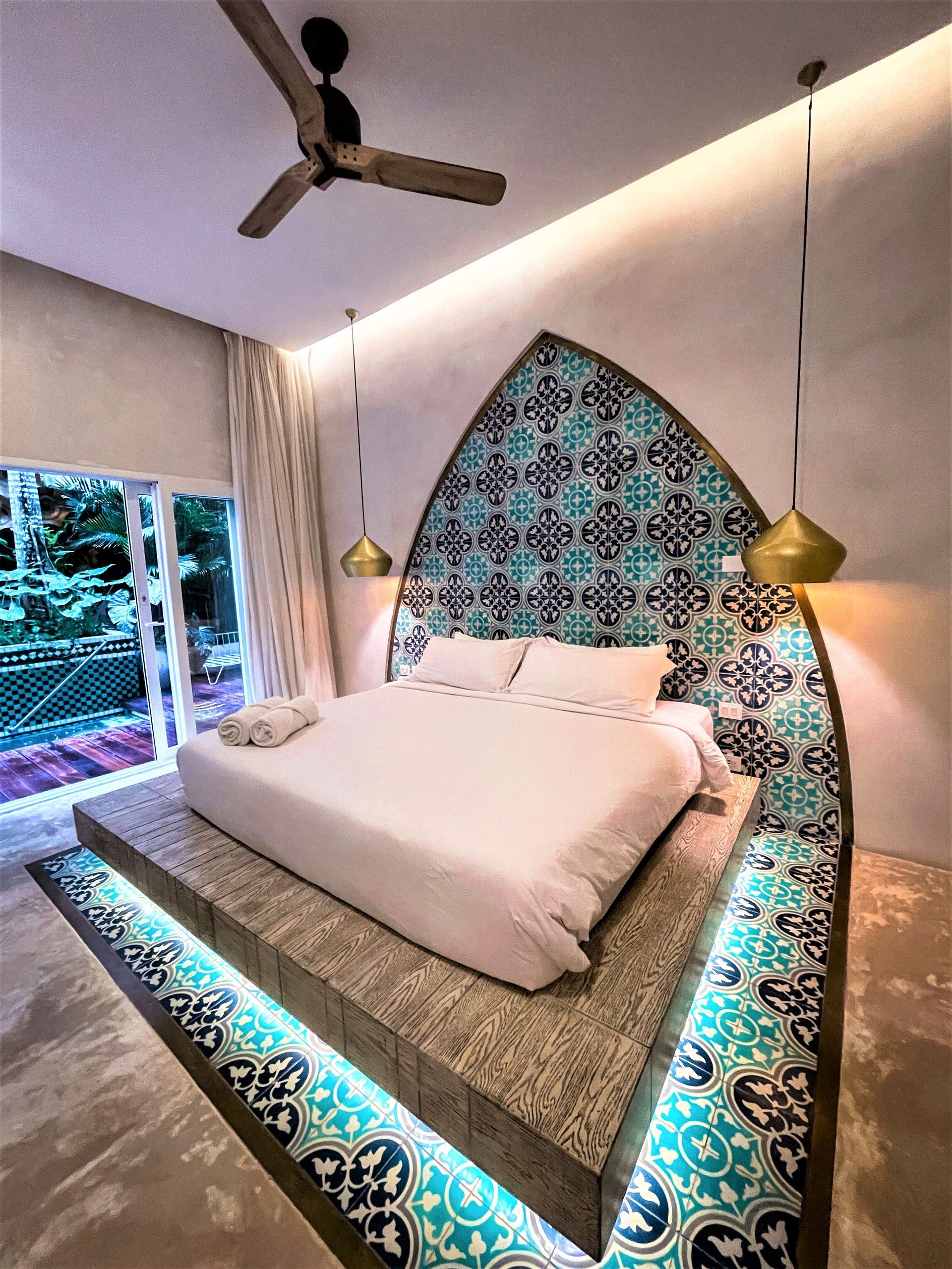 A bedroom with a large bed and a ceiling fan.