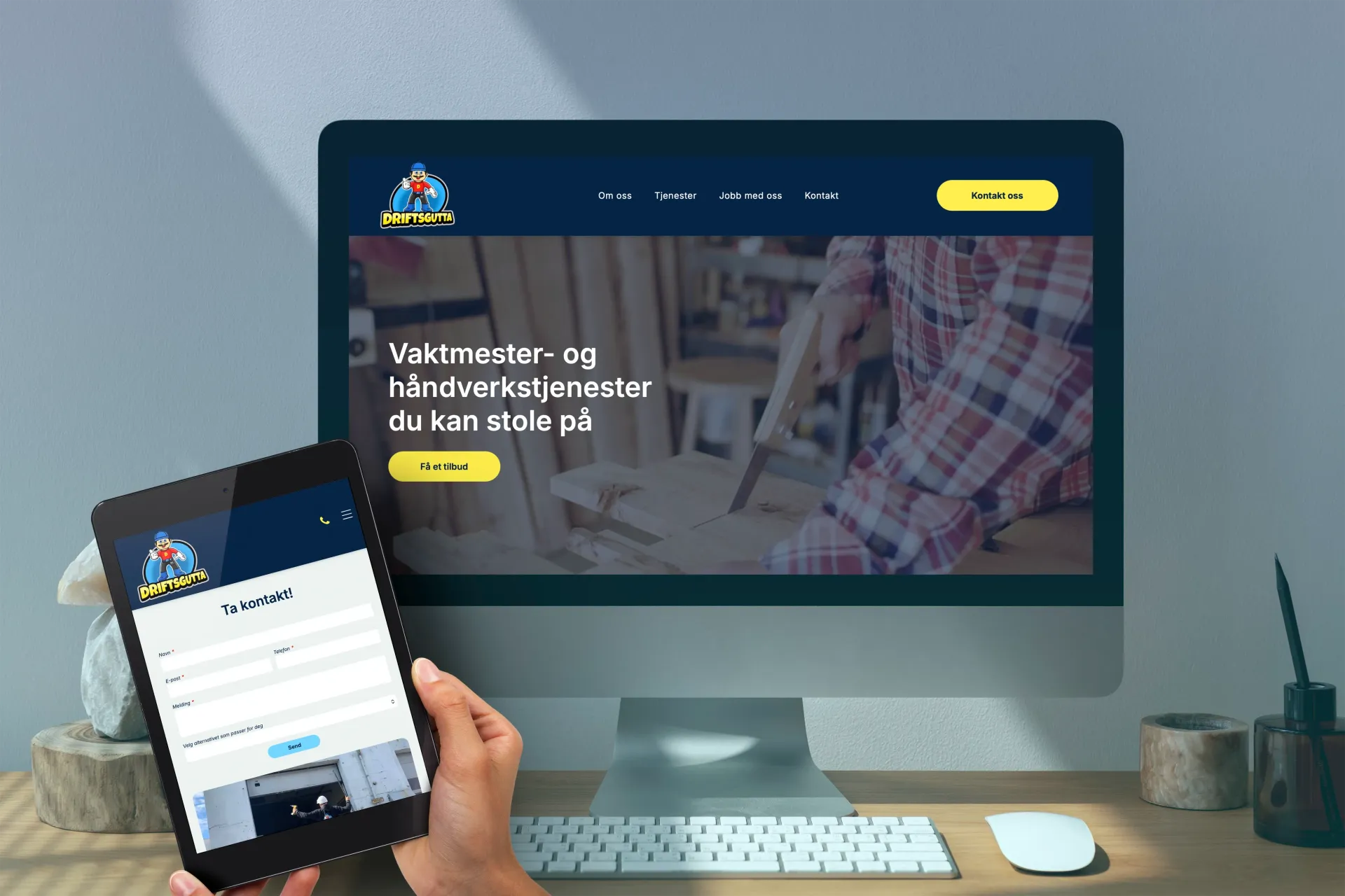Person som holder et nettbrett foran en stasjonær skjerm som viser en mockup av en nettside på et skrivebord