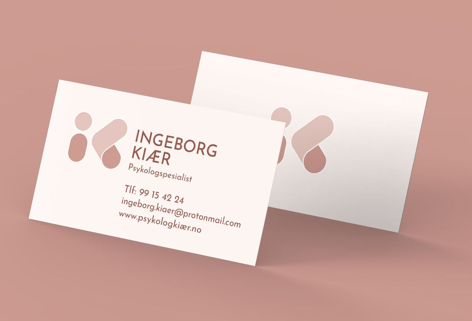 Two business cards are sitting on top of each other on a pink background.