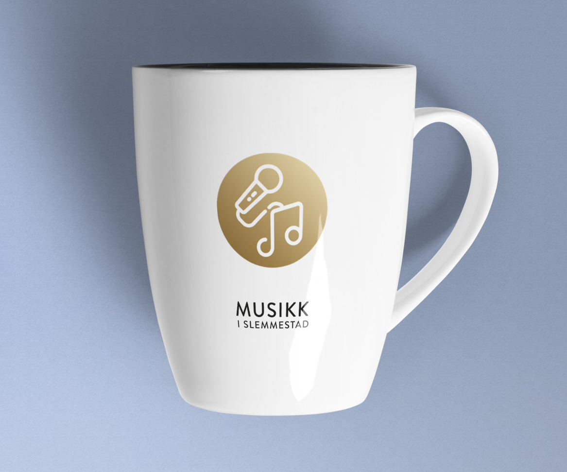 Et hvitt kaffekrus med gulllogo på står på en blå overflate.