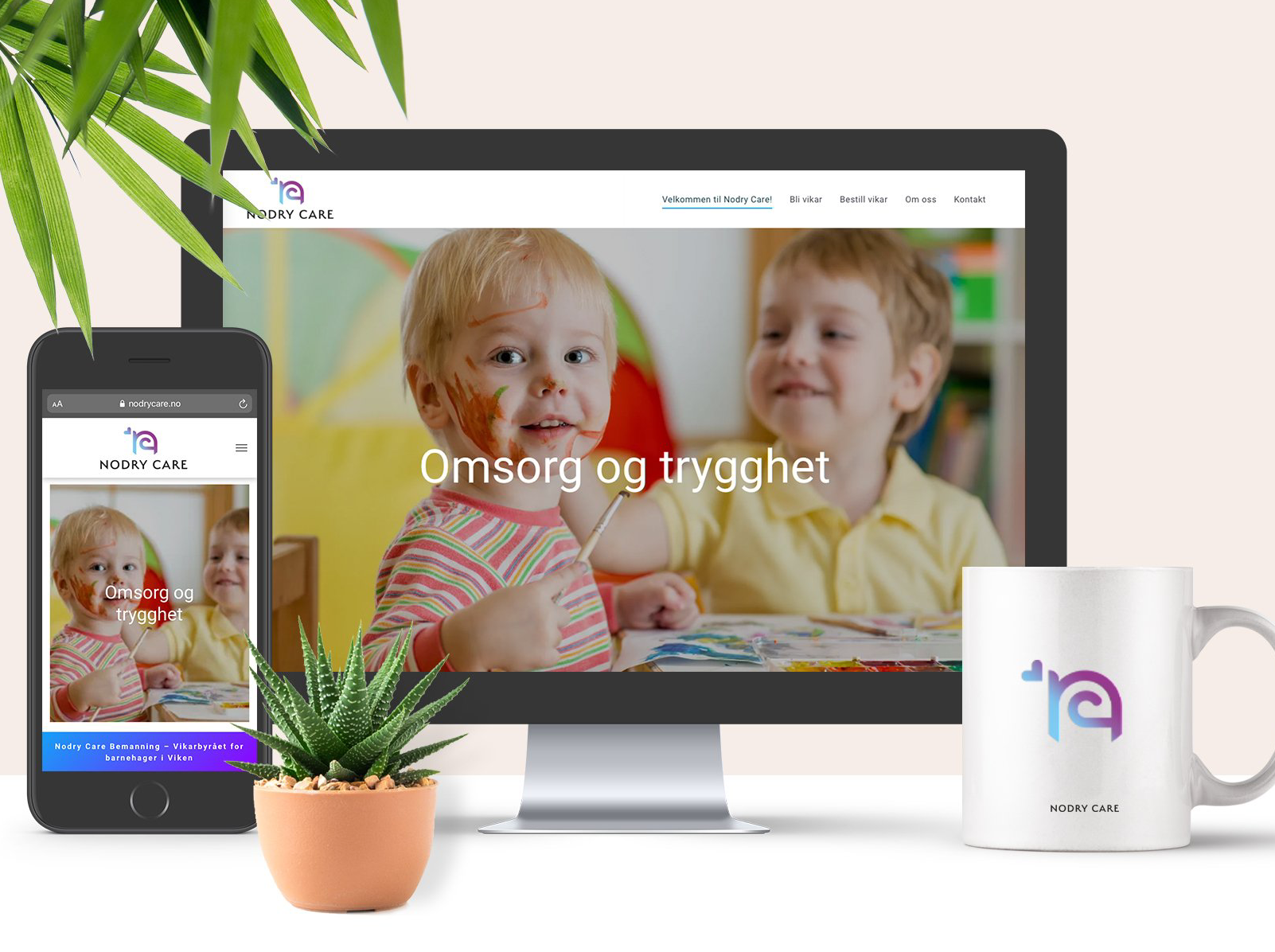 En datamaskin, telefon og krus sitter på et bord.