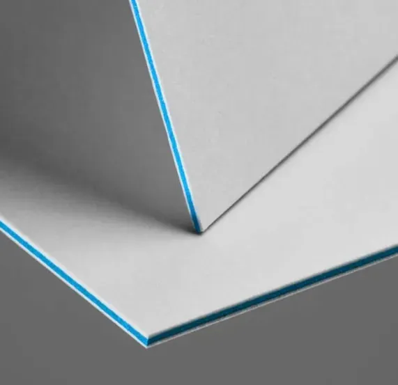 White foam board with blue edges stacked on a gray surface.