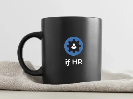 Et svart kaffekrus med ordene om hr på står på et bord.
