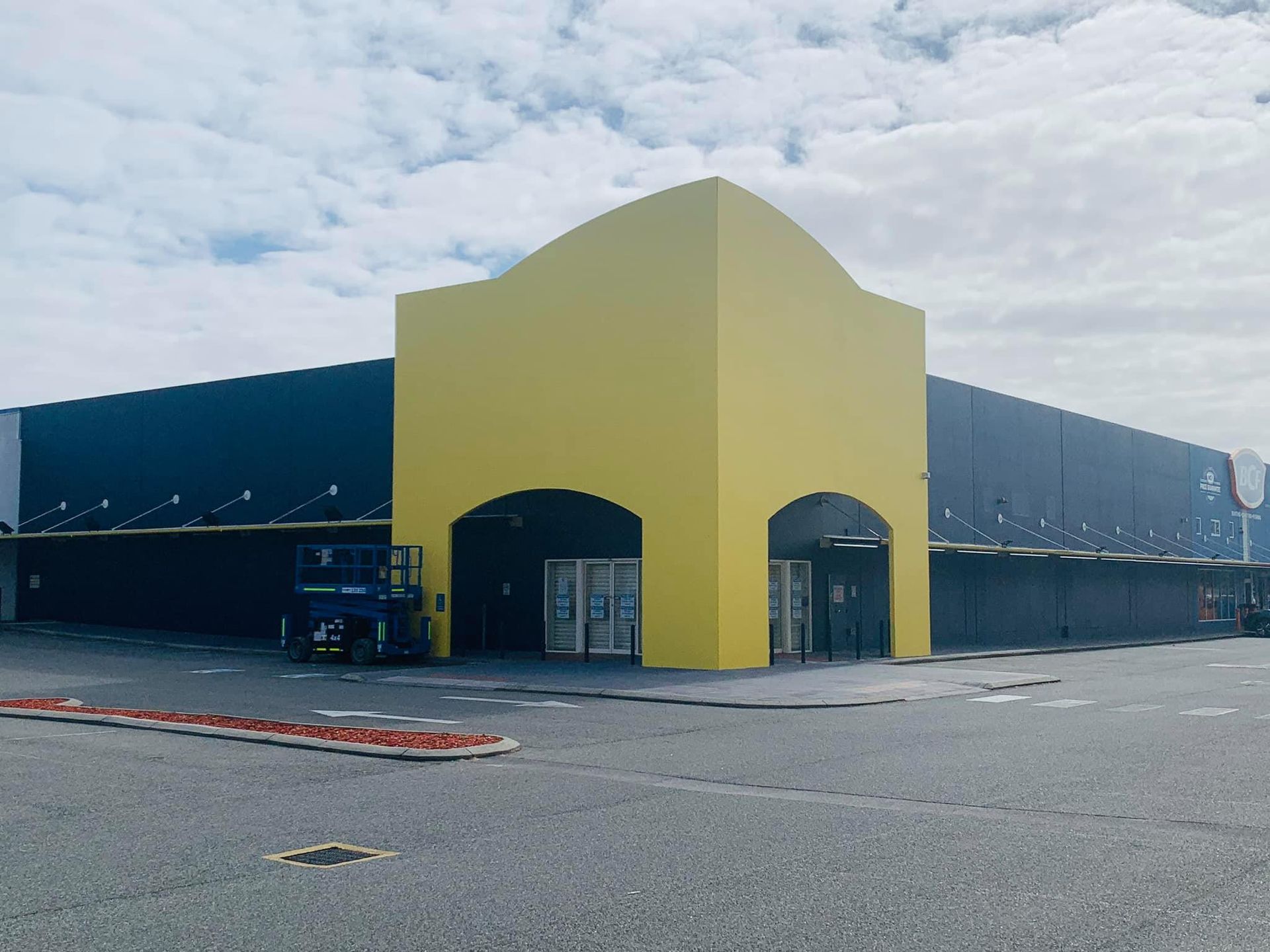 A large building with a yellow archway in front of it.