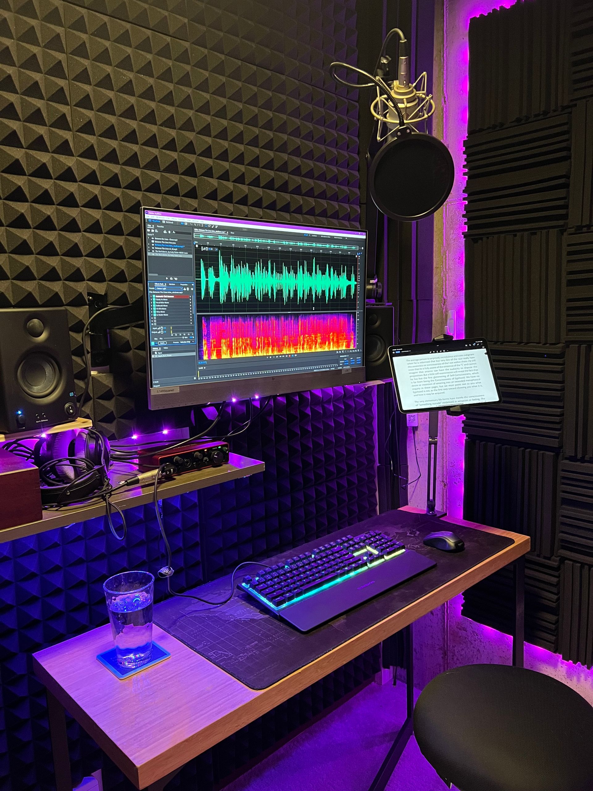 A recording studio with a computer , keyboard , and microphone.