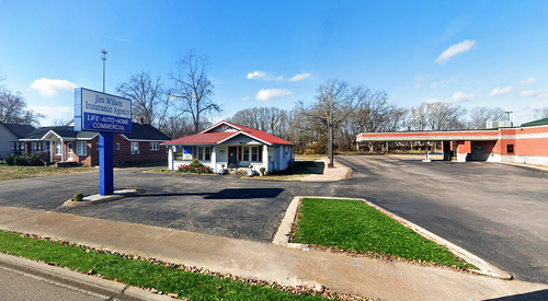 Jackson Insurance Agency storefront with brick facade, blue sign, and glass entrance in a parking lot