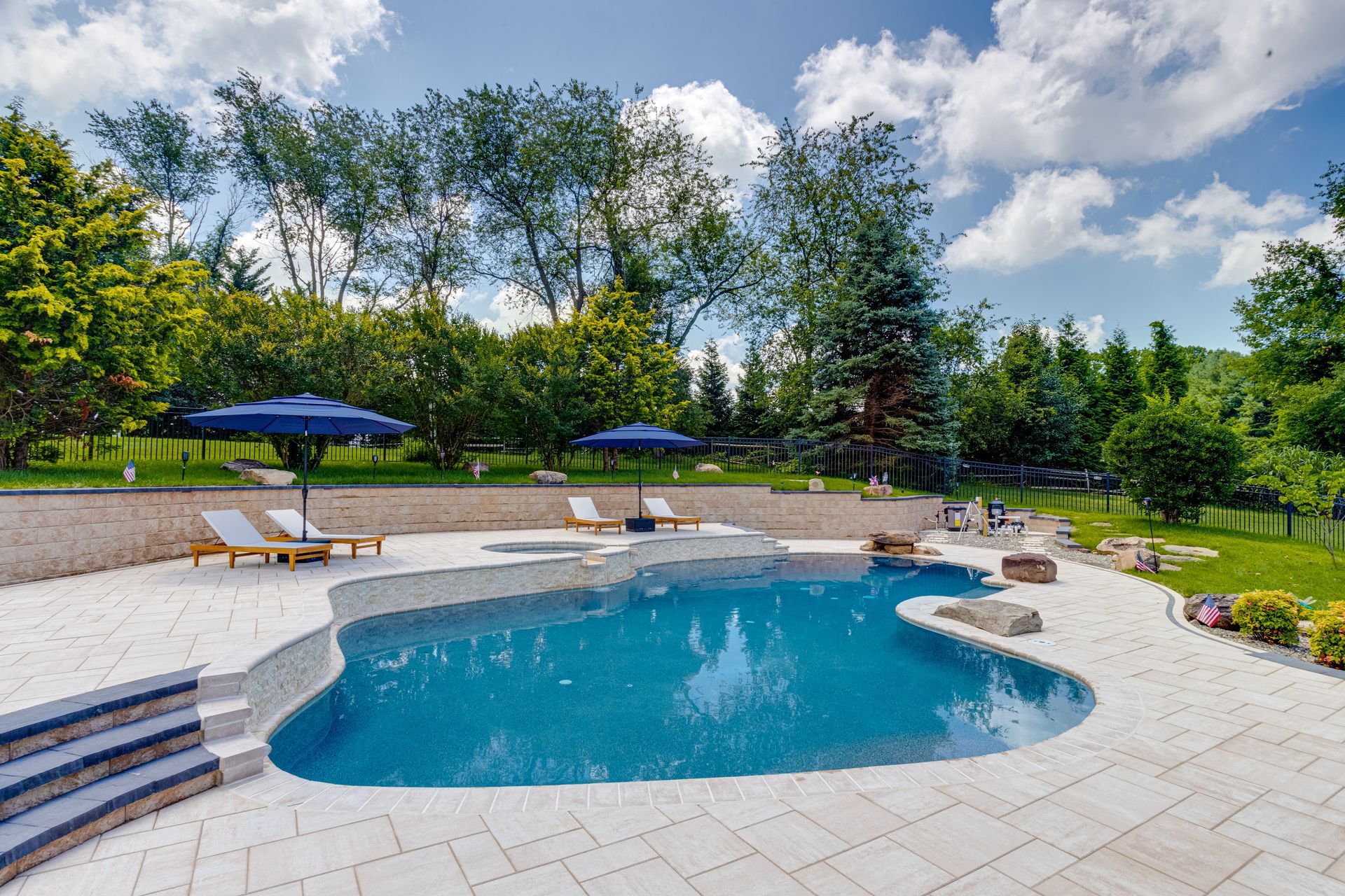 Covered backyard patio with concrete slab, dark wood trim, and a pergola beside a house.