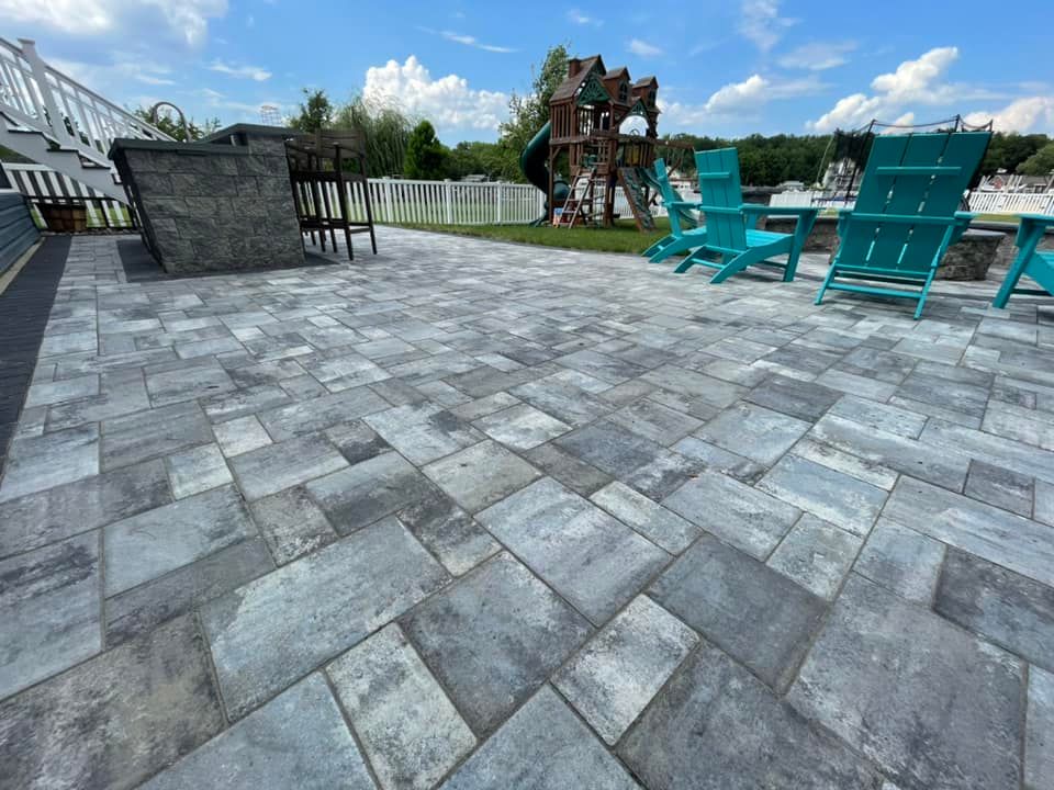 Close-up of a custom patio in Maryland featuring a built-in outdoor kitchen and stone fireplace