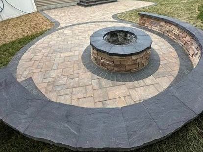 A fire pit is surrounded by bricks on a patio.