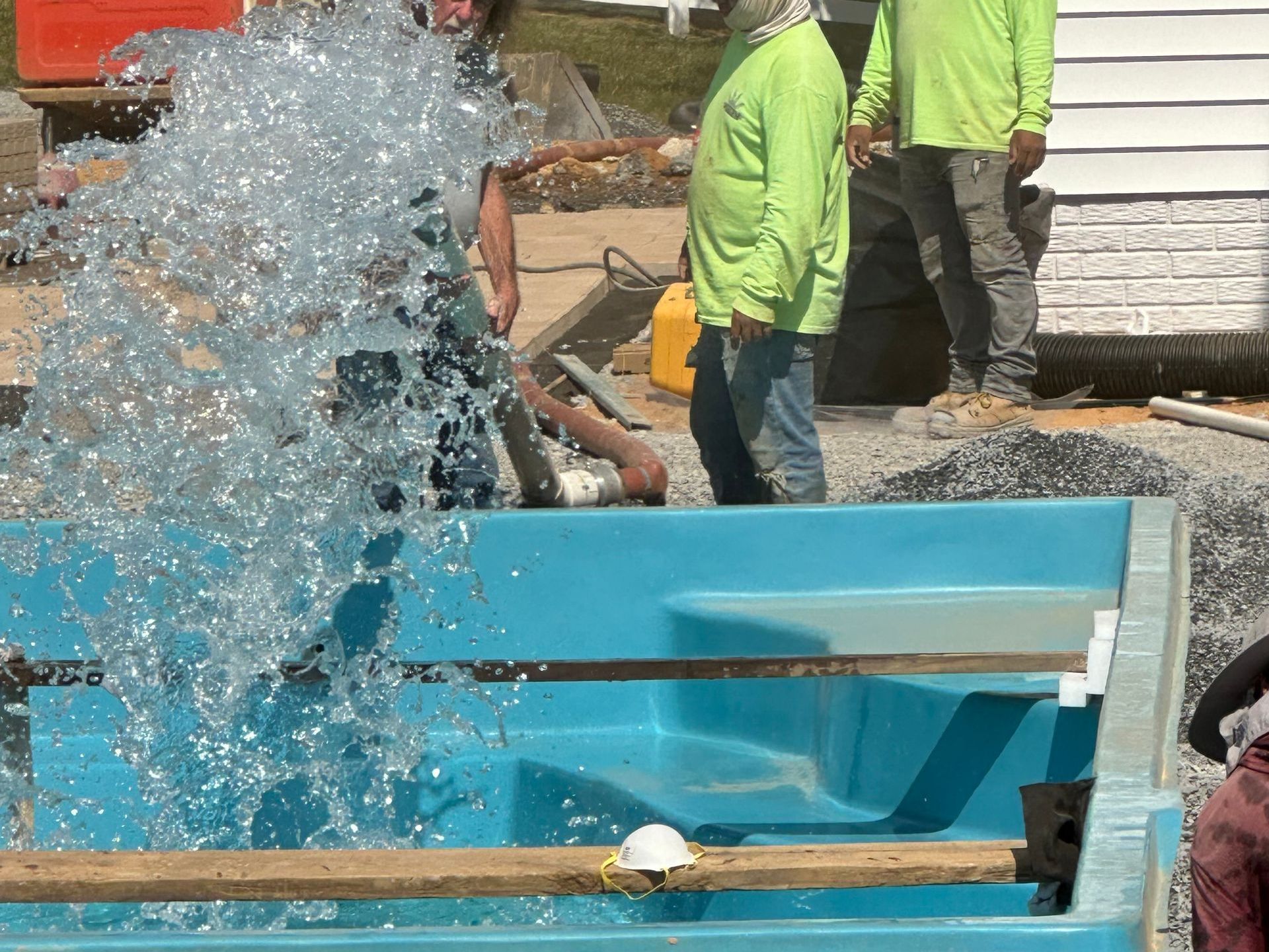 Installation of a custom fiberglass pool in progress in a Maryland backyard