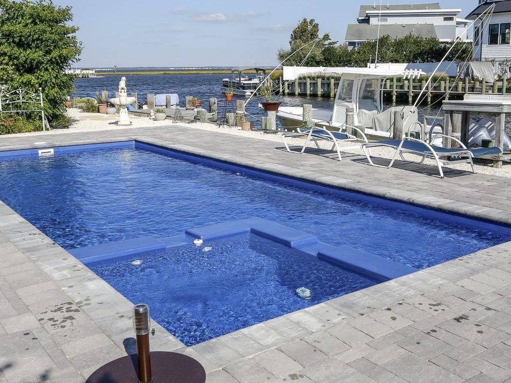 Maryland backyard with a pool and pool deck professionally installed by Xscape 2 Nature, creating a stylish and functional outdoor living space.
