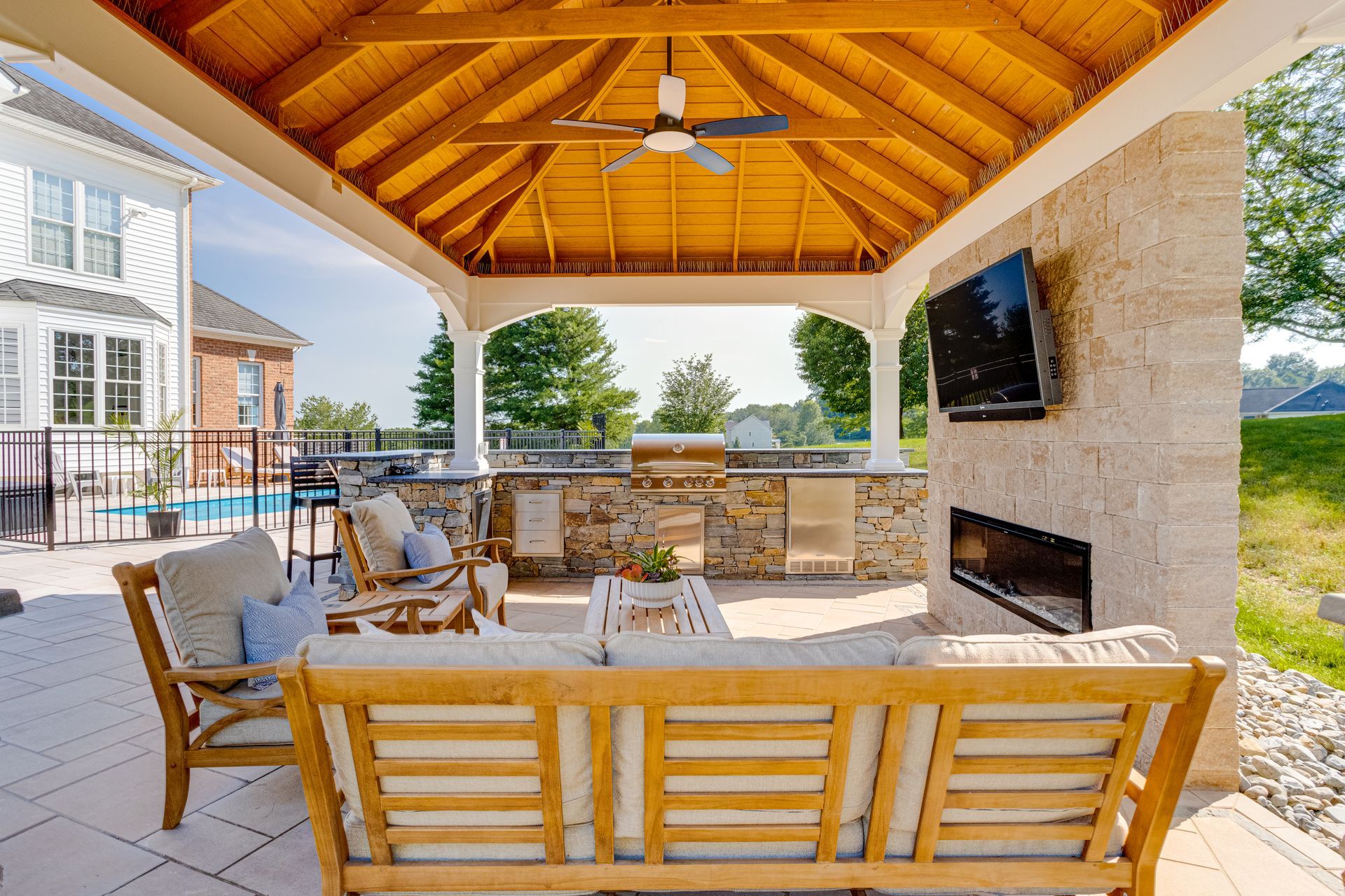 Back patio with covered pergola, concrete floor, and raised wood edging beside a house