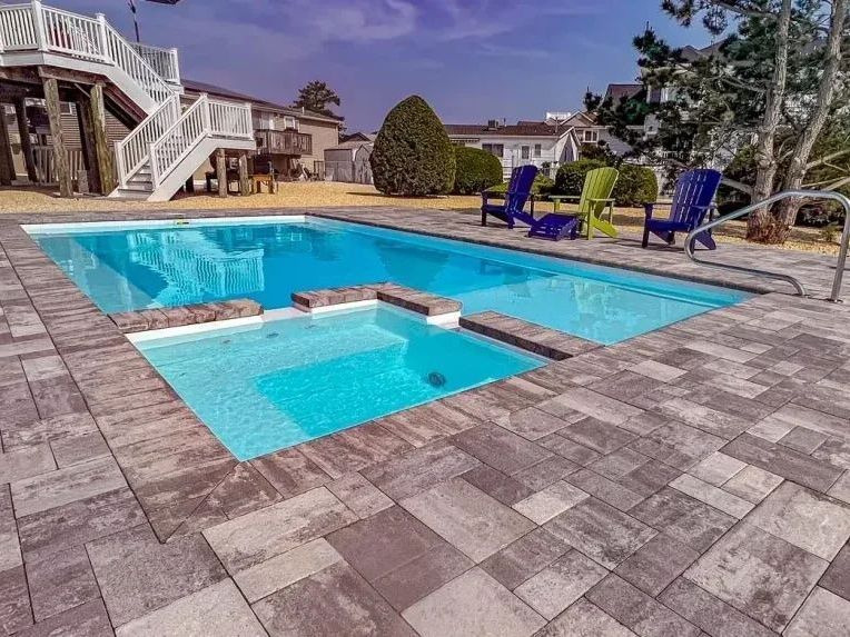 A large swimming pool with chairs around it