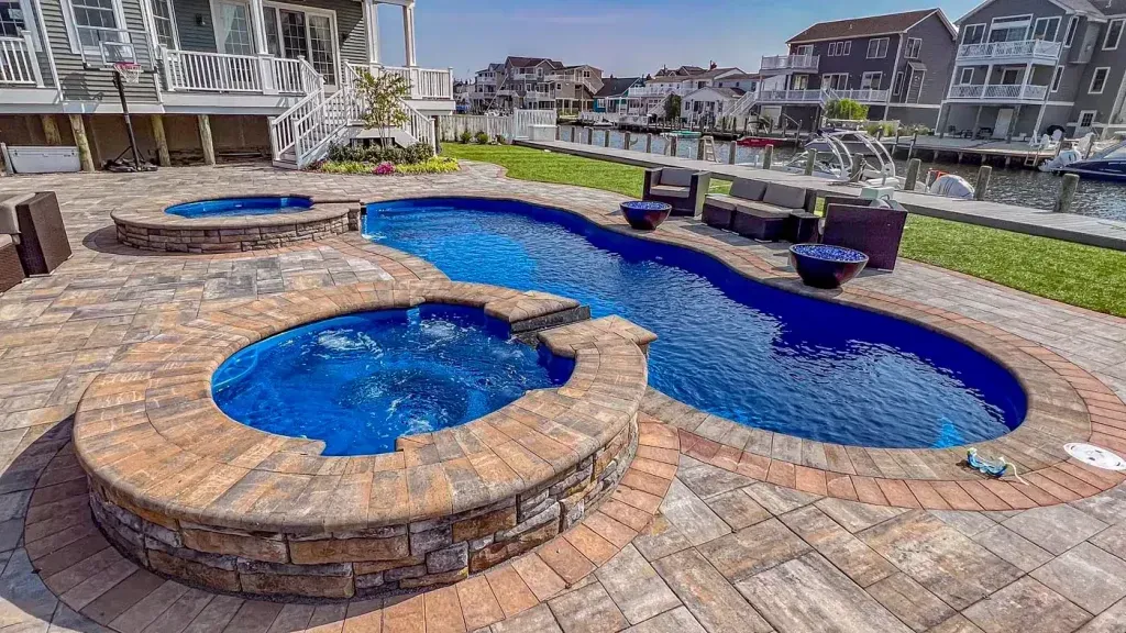 There is a large swimming pool and a hot tub in the backyard.