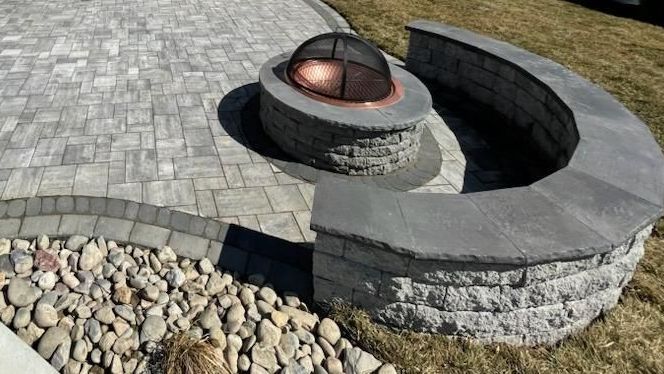 A fire pit is sitting on top of a brick patio.