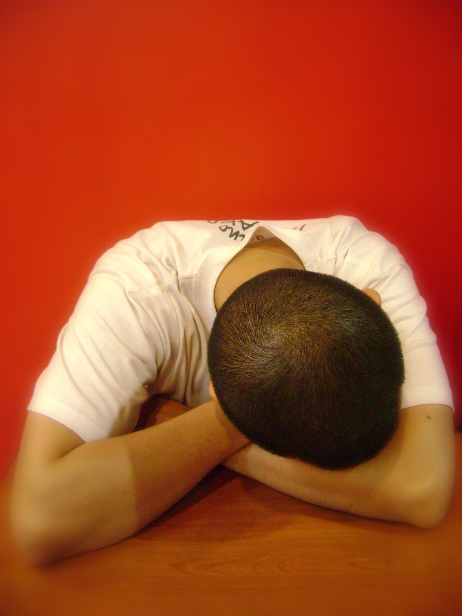 A man is laying down with his head in his hands