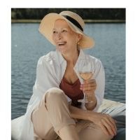 A woman is sitting on a boat holding a glass of wine.