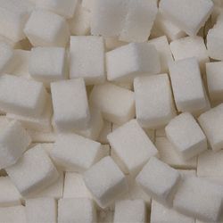 A pile of white sugar cubes on a table.