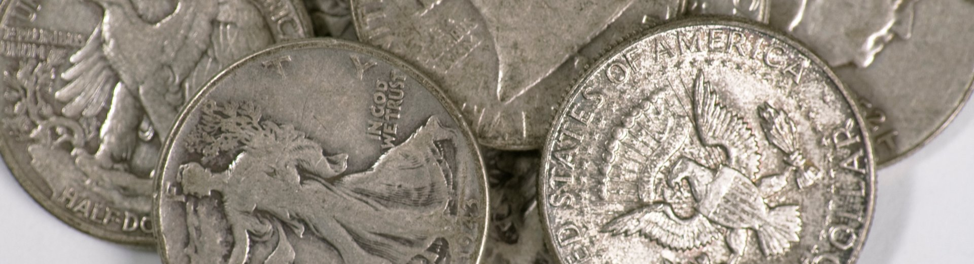 small pile of u.s. half dollars on a white background
