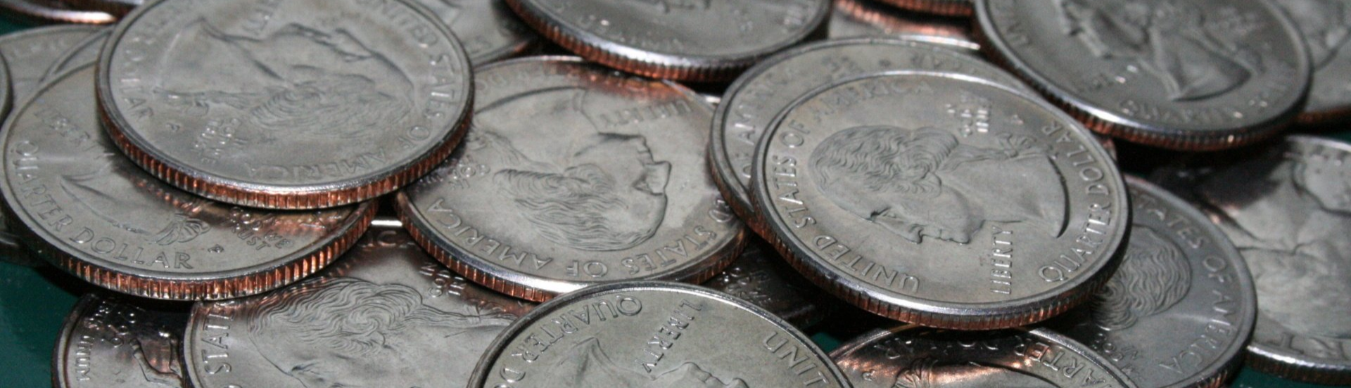 pile of u.s. washington quarters on a teal background