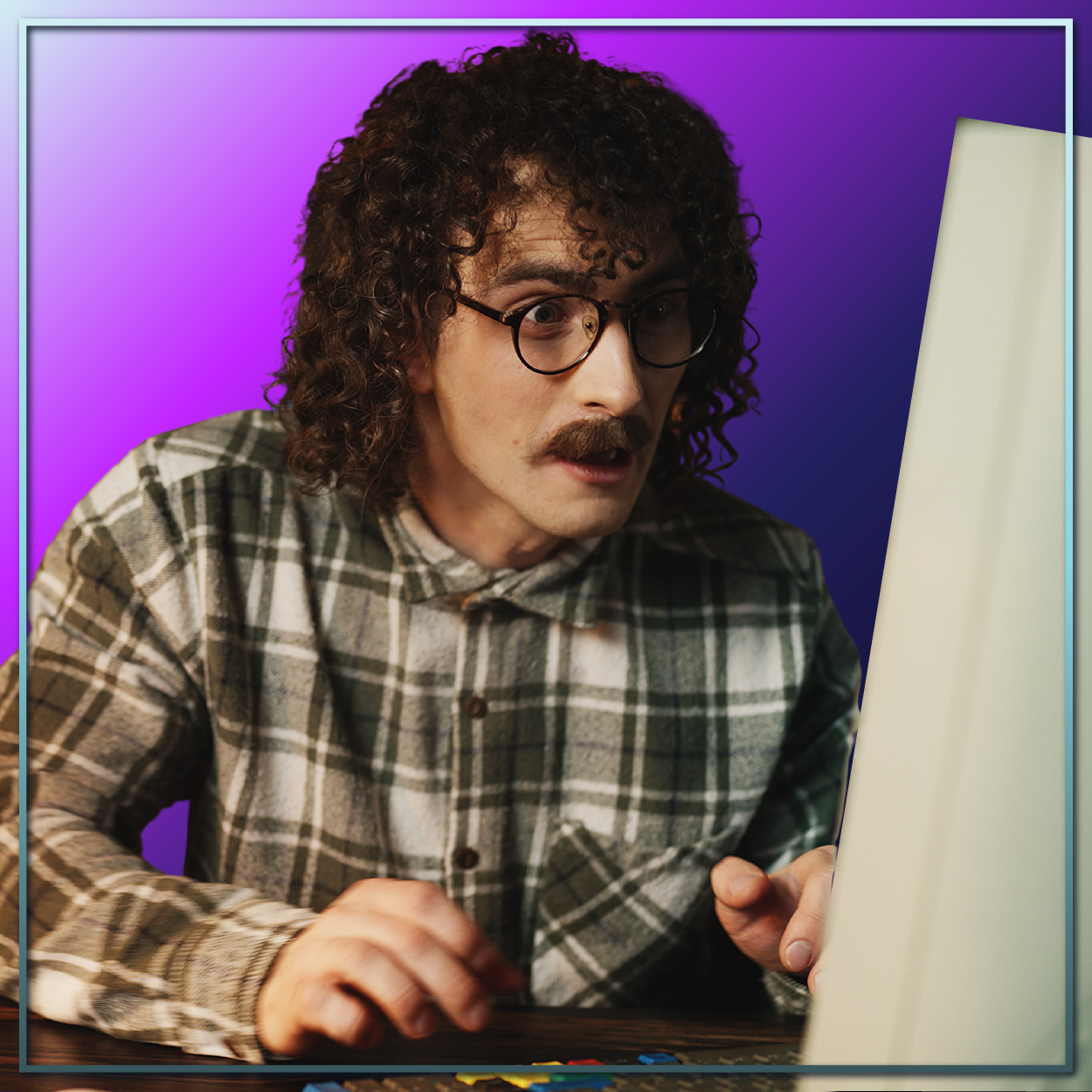 Person with curly hair and glasses leaning toward a laptop against a purple background