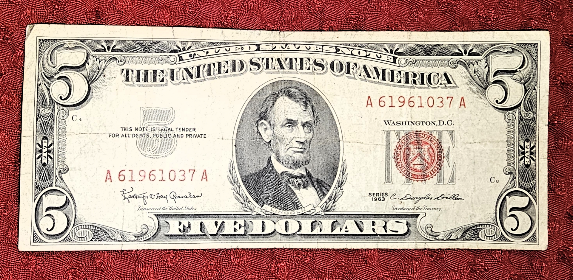 US five-dollar bill with Abraham Lincoln portrait and red seal