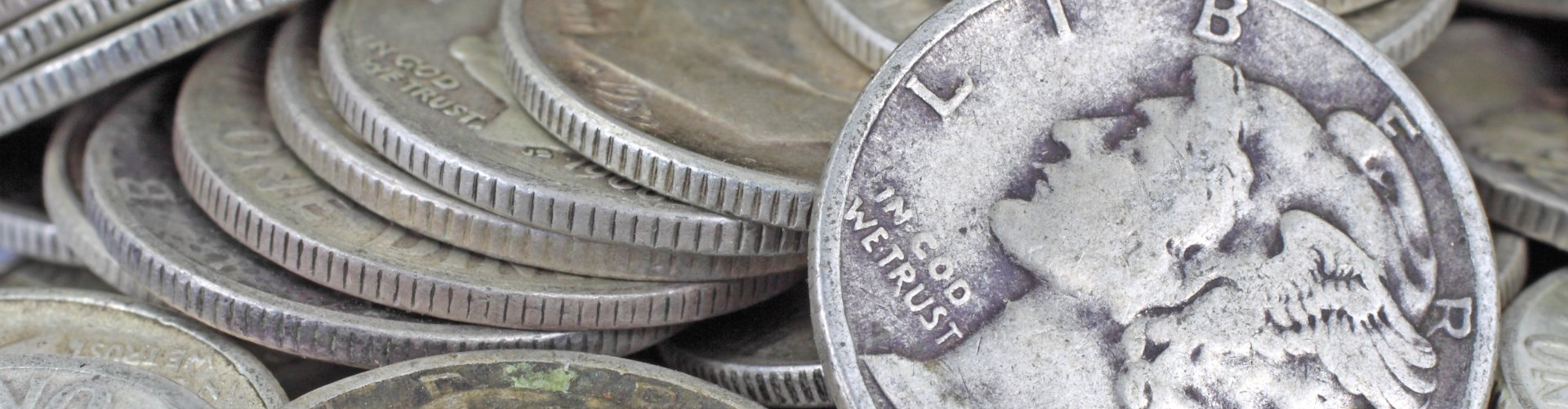 pile of mercury dimes with one dime facing the viewer