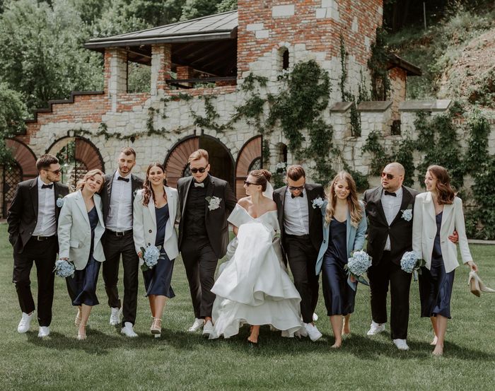 A bride and groom are walking with their wedding party.