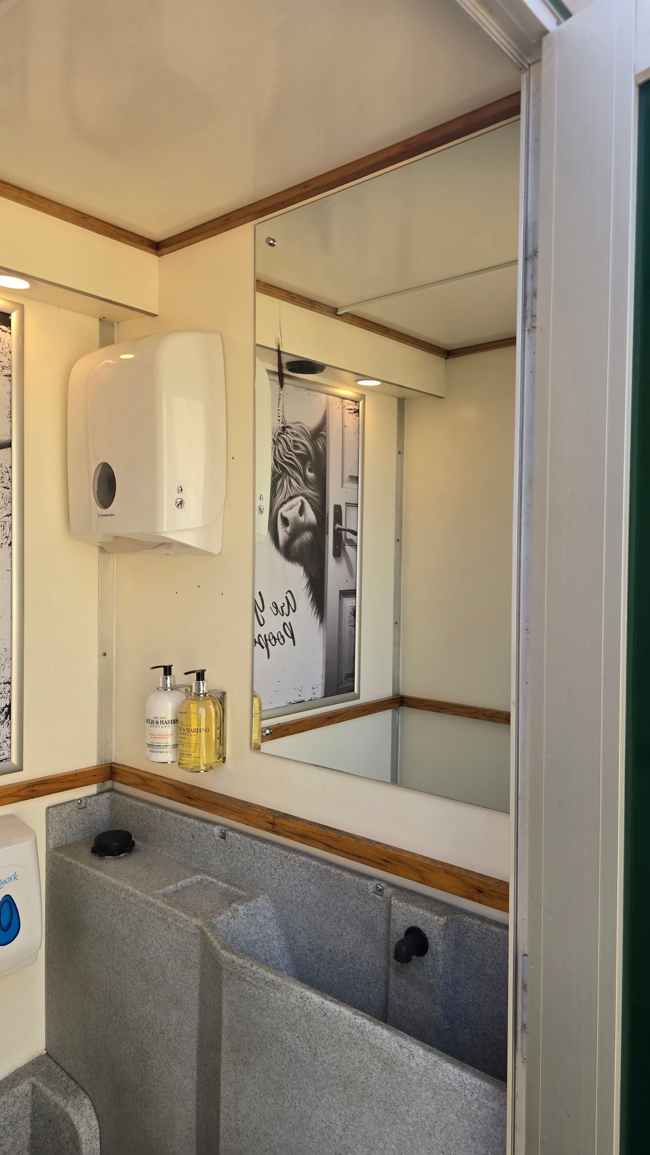 Bathroom sink and mirror with granite counter, wall cabinet, and shower curtain in a small tiled washroom.