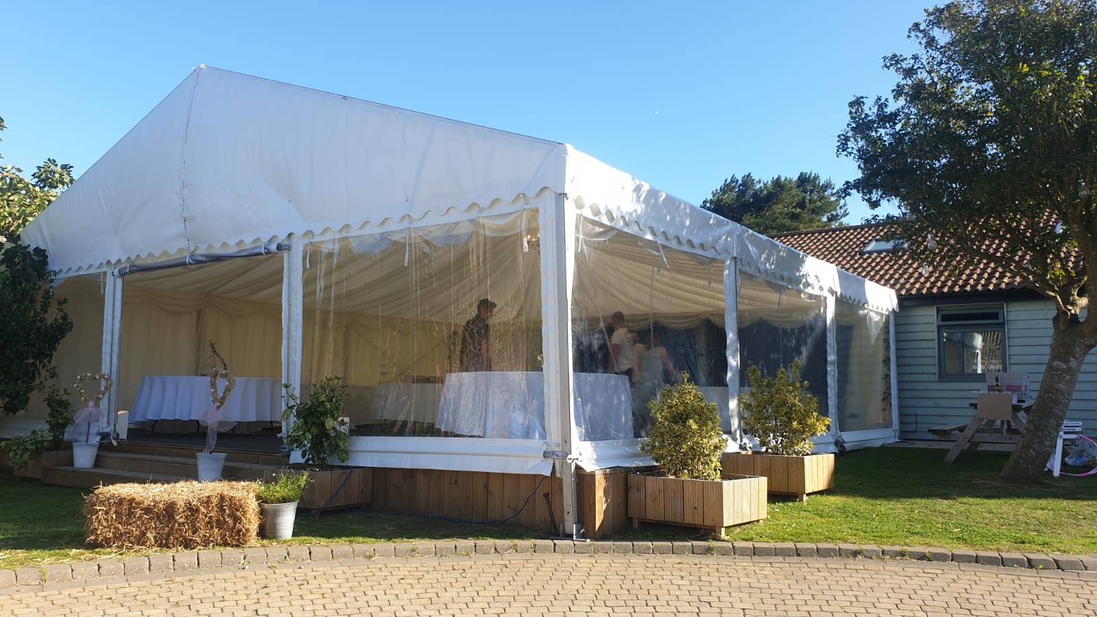 A large white tent is sitting in front of a house