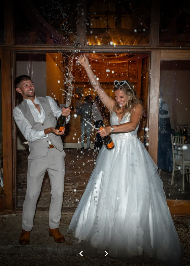 A bride and groom are celebrating their wedding with champagne.