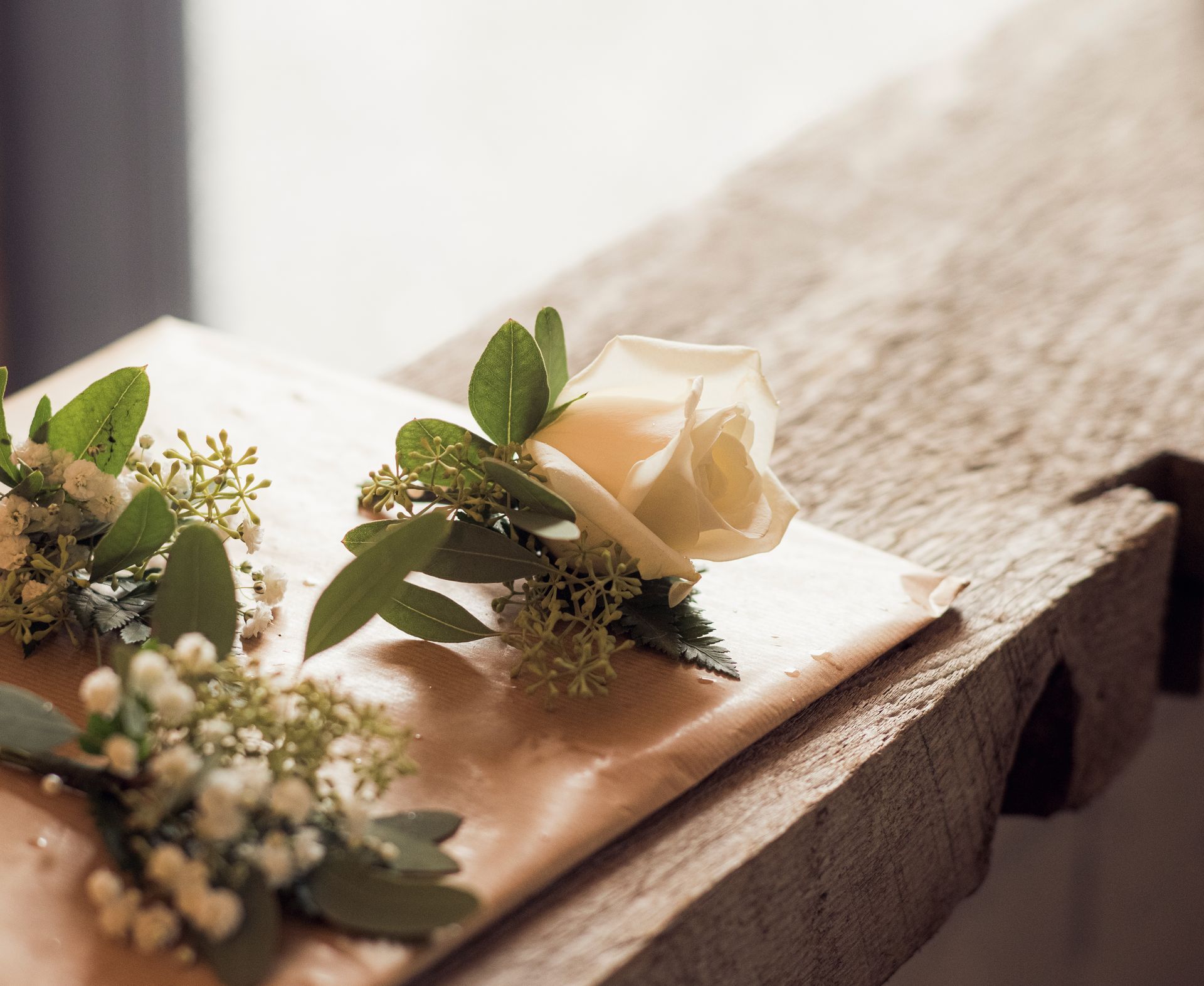 A couple of flowers sitting on top of a wooden table.