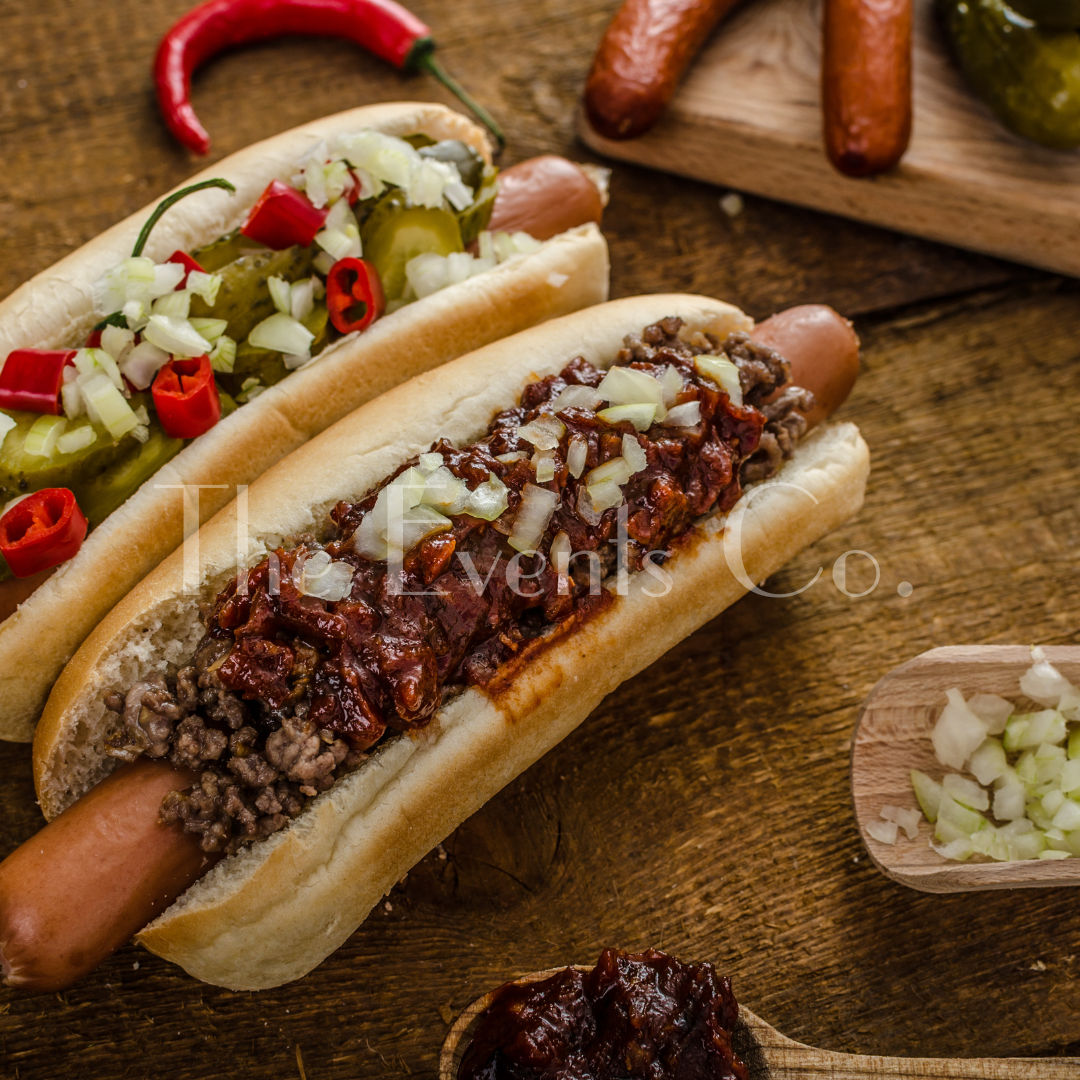 Two hot dogs with toppings on a wooden table