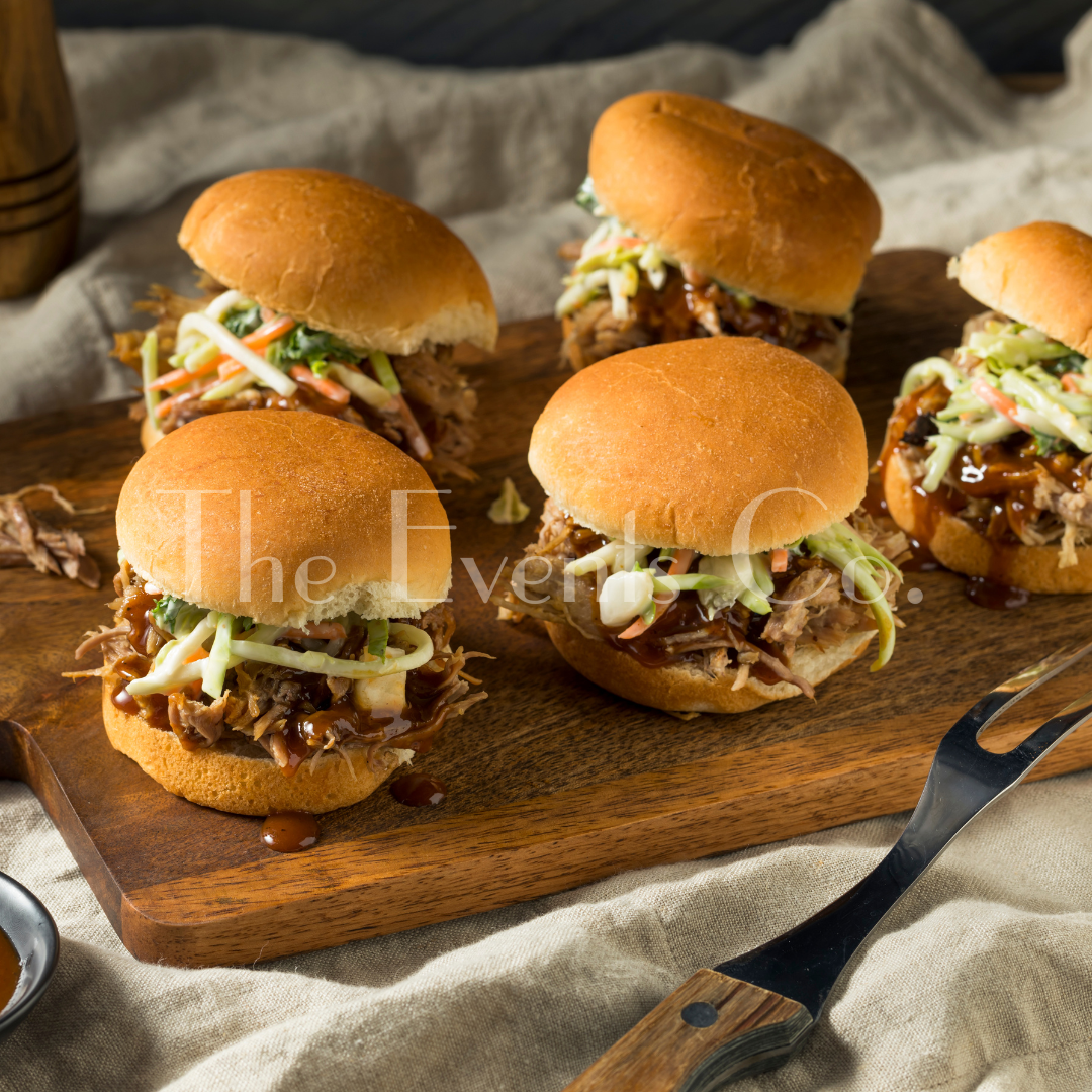 A bunch of pulled pork sandwiches on a wooden cutting board