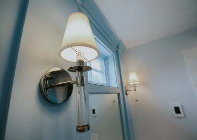 A lamp is hanging on a wall next to a window.