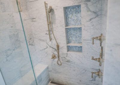 A bathroom with a walk in shower and a glass door.
