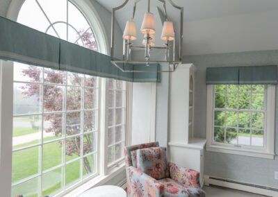 A living room with a chair and a chandelier.