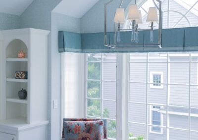 A living room with a large window and a chair in front of it.