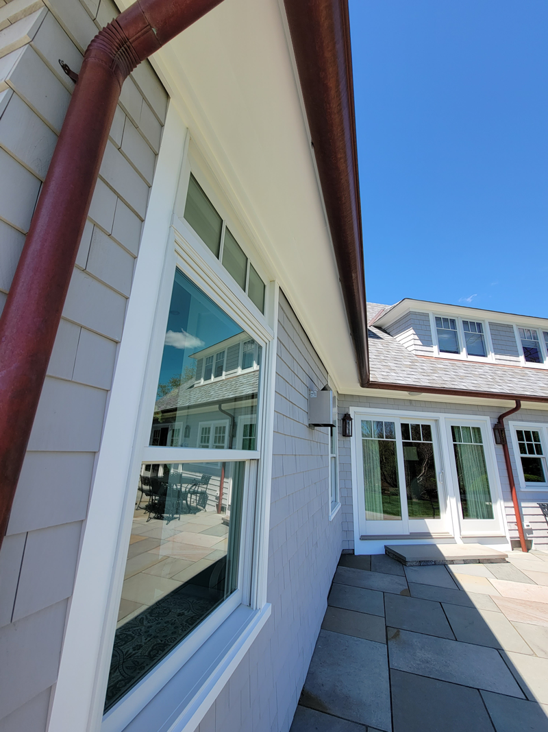 A house with a lot of windows and a red gutter