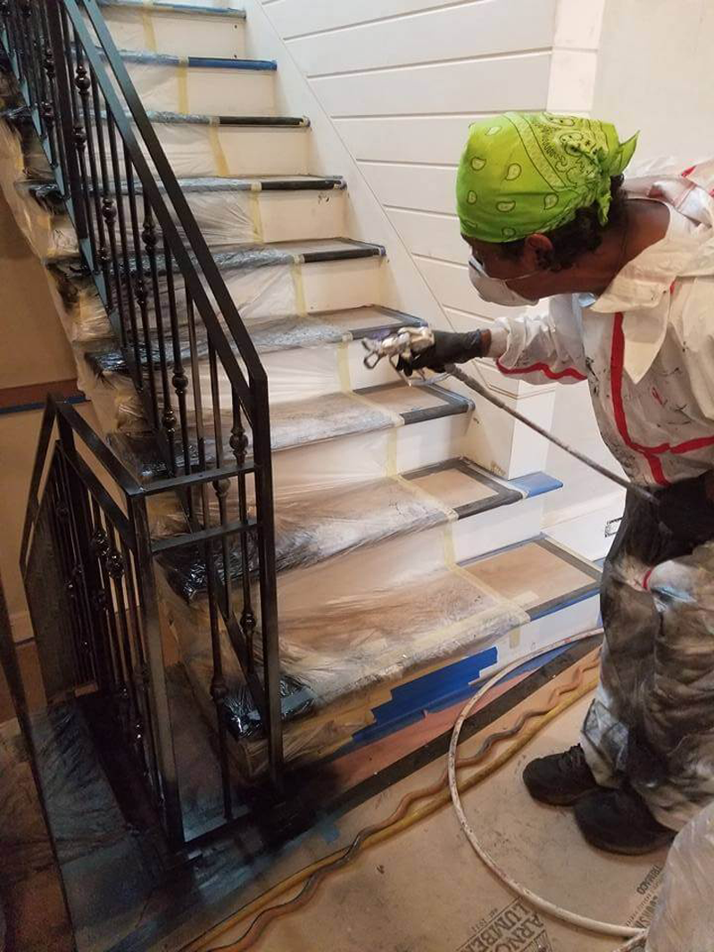 A man is spraying paint on a set of stairs.