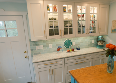 A kitchen with white cabinets and a clock on the counter.