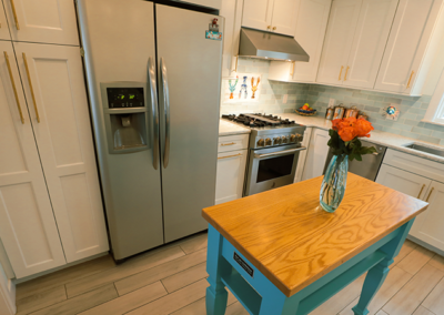 A kitchen with a blue table and a vase of flowers on it