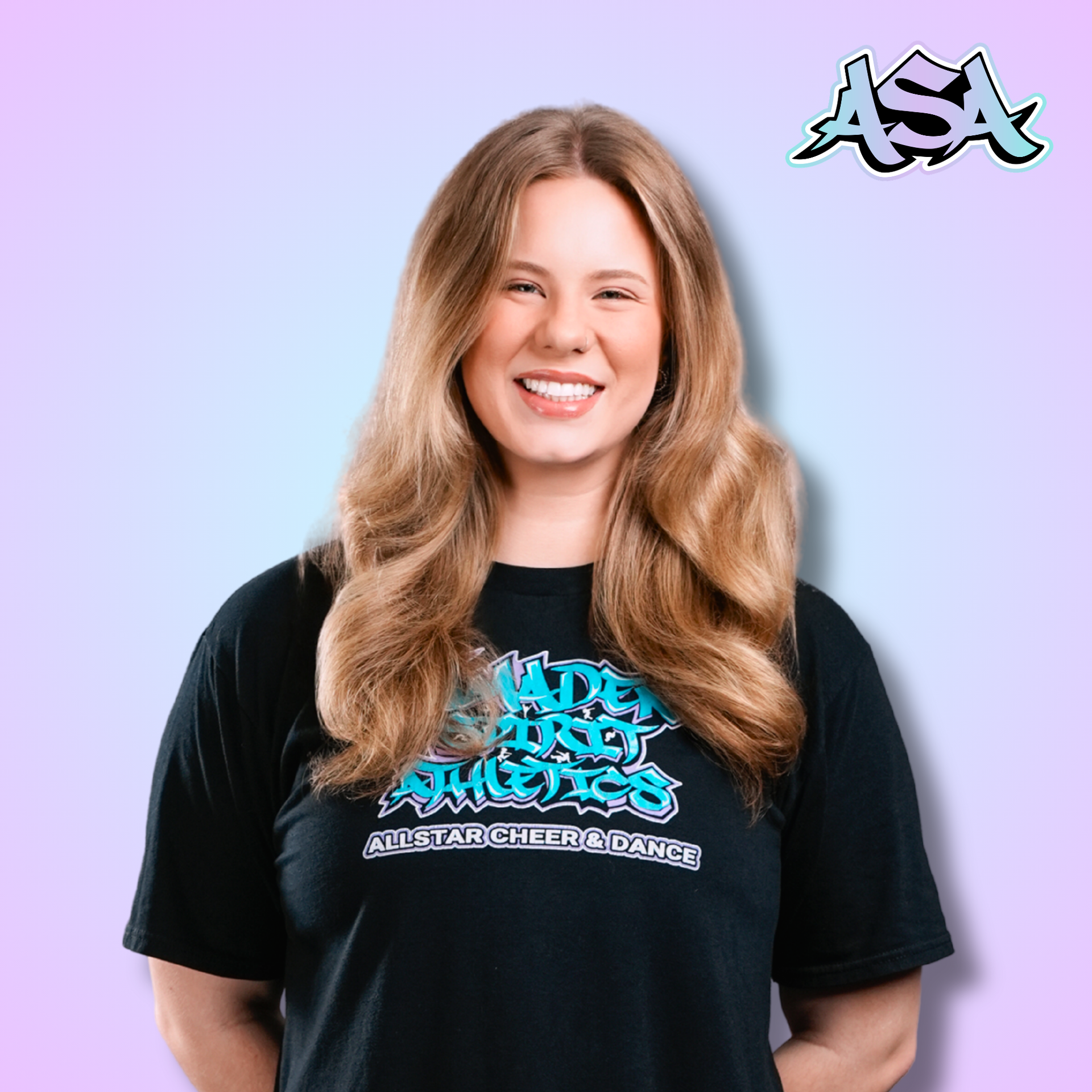 A woman wearing a black t-shirt with graffiti on it is smiling.